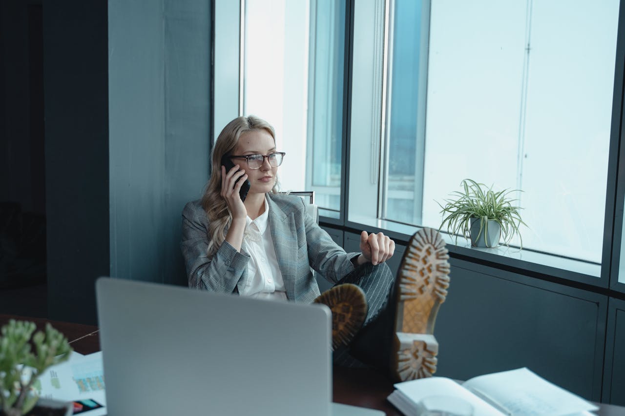services-03 Professional woman in office setting, relaxed yet focused, making a call.