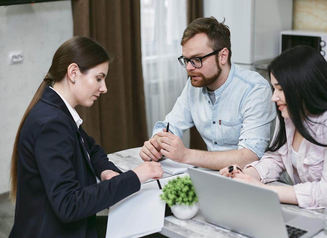 who-we-are A couple discusses financial documents with their advisor, highlighting investment strategies.